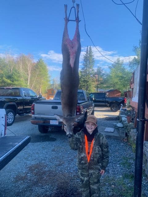 Young hunter with deer at Swiftwater check station