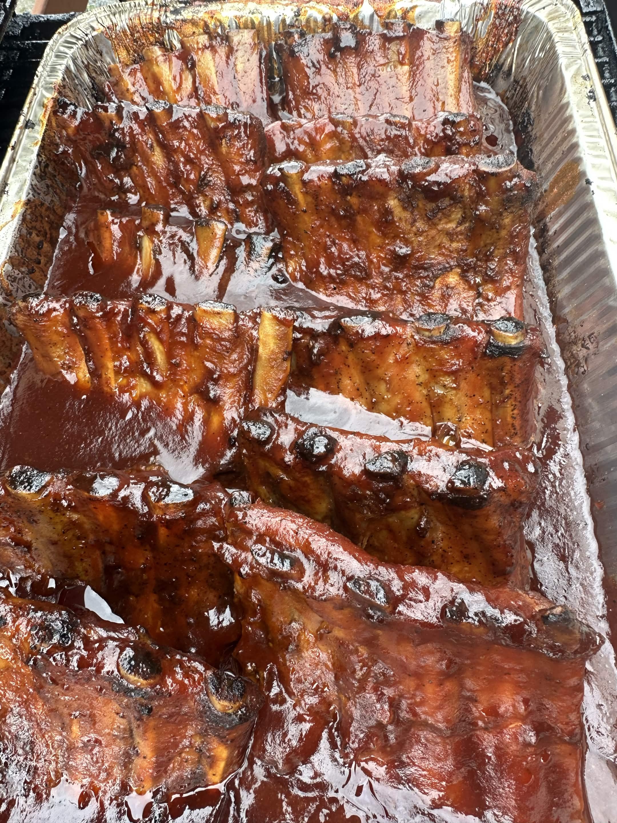 Tray of saucy BBQ ribs for catering
